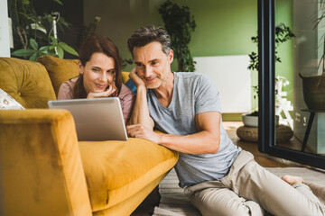 Man and woman with hand on chin looking at digital tablet