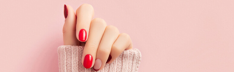 Manicured womans hand in sweater. Manicure, pedicure design trends