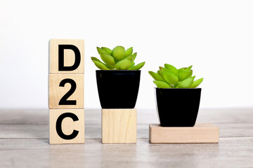 D2C. text on wooden boards on a white background on a wooden table