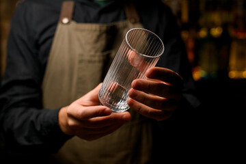 beautiful view of empty transparent tall cocktail glass in male hands