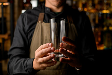 close-up shot of caucasian male hands holding an empty drinking glass