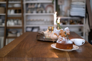 Christmas cake on a wooden table and lit candles