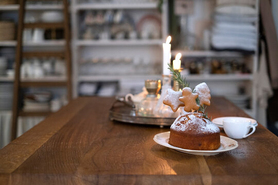 Christmas cake on a wooden table and lit candles