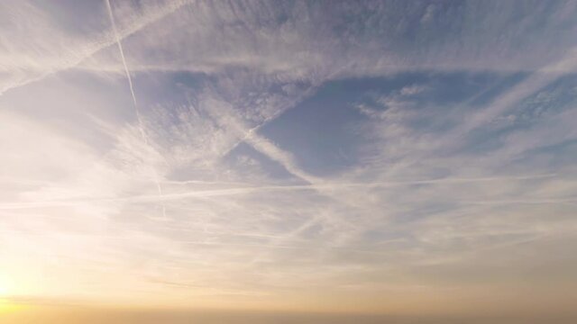 A wide-angled panoramic view of airplane contrails across the sky.