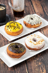 Delicious donuts decorated with different decorations on wooden table