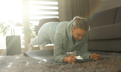 Fototapeta na wymiar Woman doing plank exercise. Home fitness training concept.