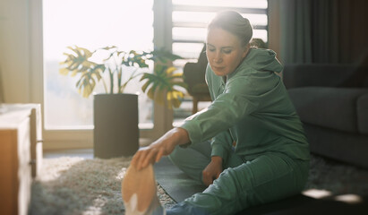 Woman doing stretching exercises. Home fitness training concept.