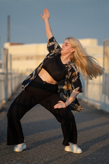 Girl dancing on the bridge at sunset
