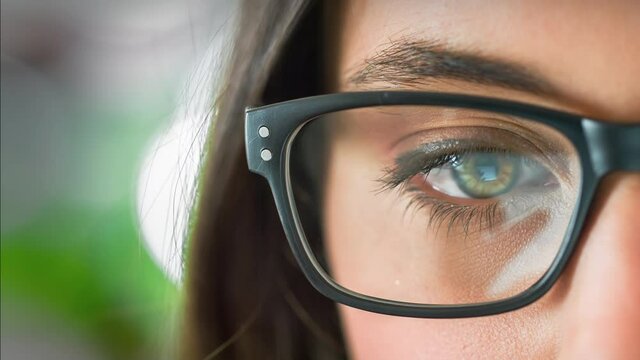 Young Woman Eye Glasses Reflection. Caucasian Female Looking at Electronic Device with Animated Videos Reflected in her Eyeglasses. All Videos Included in my Portfolio.