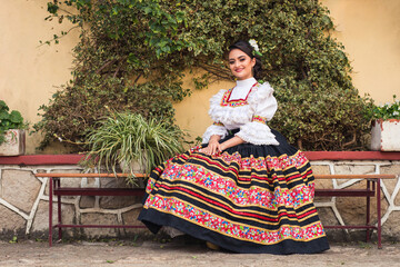 Woman in folk costume sitting on the bench. customs and traditions of the world. typical Colombian...