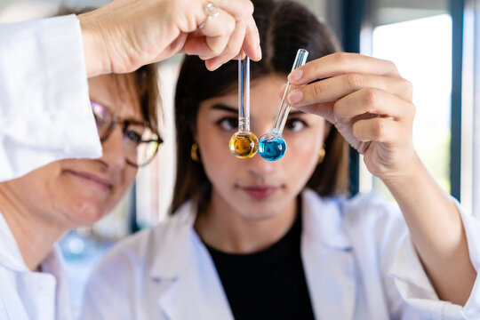 Female scientists examining chemical in test tubes at laboratory