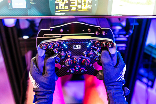Male gamer holding controller while playing video game at studio
