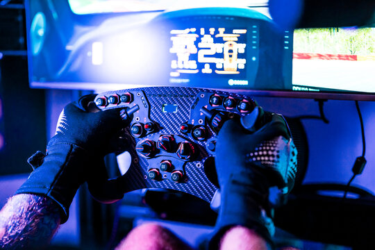 Male gamer playing game on computer through controller at studio