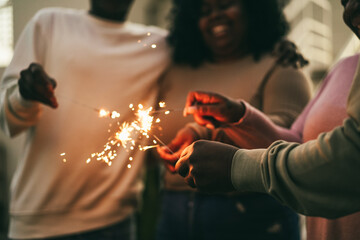 Happy african family using sparklers outdoor at home - Focus on right hand - New year celebration...