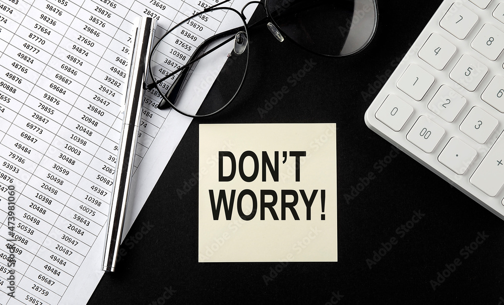 Poster concept don't worry message on sticker with glasses,chart and calculator on the black background