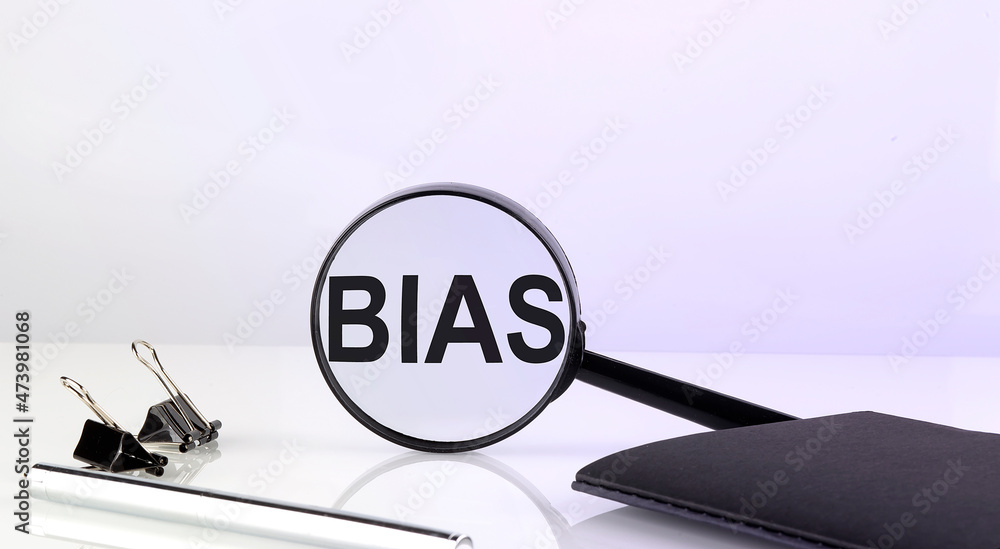 Poster bias concept. magnifier glass with text with notebook and pen