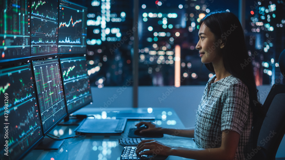 Poster portrait of a financial analyst working on computer with multi-monitor workstation with real-time st