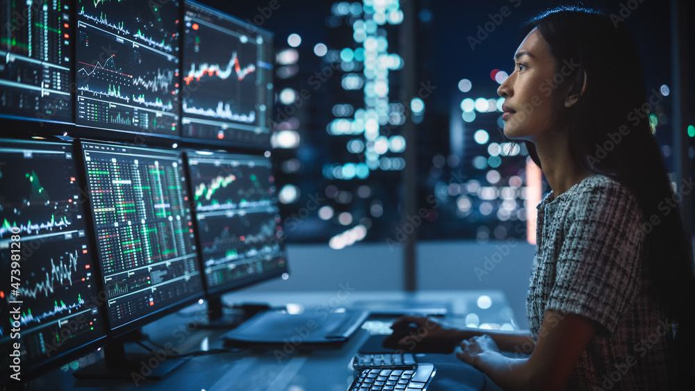 Poster portrait of a financial analyst working on computer with multi-monitor workstation with real-time st