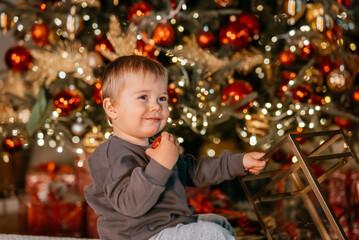 Fototapeta na wymiar Little boy playing by the christmas tree