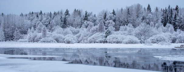 Obraz premium River in a cold winter landscape with snow and frost