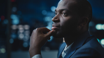 Portrait of a Financial Project Manager Working on Computer in an Office Late in the Evening....