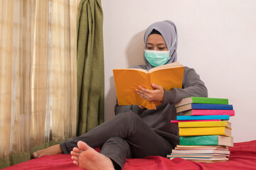 Asian women wearing hijabs wearing masks are working from home