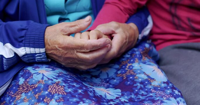 Close-up of an old woman's hand with deep wrinkles stroking children's hands. Grandmother takes pity on her grandson. A happy family.