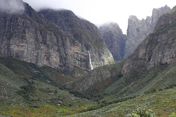 Waterfalls streaming down the majestic du Toitskloof mountains with rain clouds on the peaks