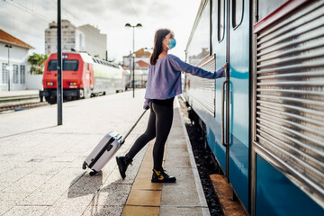 A tourist with luggage and mask want to board the train