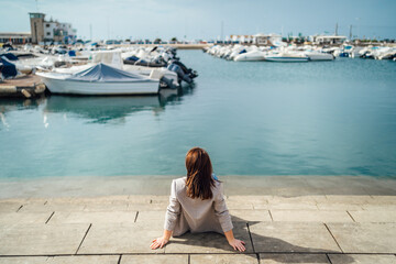Portrait of young woman sitting by the marina