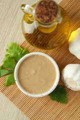 Concept of tasty food with tahini sauce on light wooden background