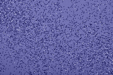Glitter confetti in Very peri color, violet abstract background.