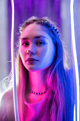 Naklejka na ściany i meble Cinematic night portrait of girl and neon lights. Fashion. Woman in Colorful neon light. girl in disco, makeup dance. Party disco neon nightclub vibes. creative art neon pink blue light.
