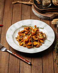 Portion of gourmet fried mushrooms with onion garnish