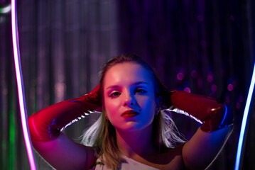 Naklejka premium Cinematic night portrait of girl and neon lights. Fashion. Woman in Colorful neon light. girl in disco, makeup dance. Party disco neon nightclub vibes. creative art neon pink blue light.