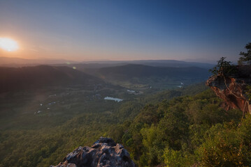 Stone cliff with forest, valley and mountain in sunset time