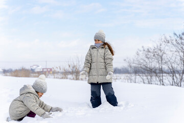 Fototapeta na wymiar Happy children play snowballs, run, throw snow. Funny kids play games indoors in the winter with snow