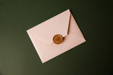 Beige envelope on a green background. Congratulatory envelope, invitation.