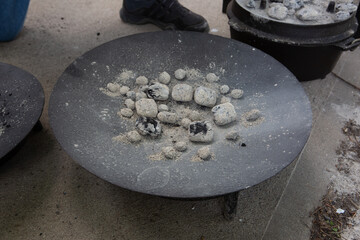 Bowl with the light gray coal for cooking in it