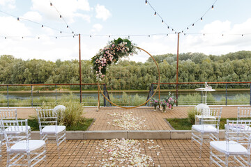Round wedding arch decorated with fresh flowers. Ceremony area