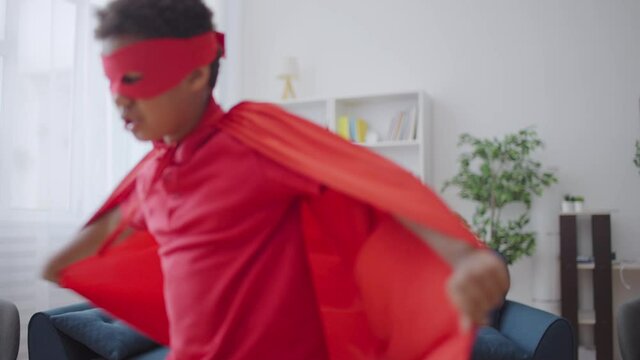 Happy children wearing superhero costumes fooling around, playing game together