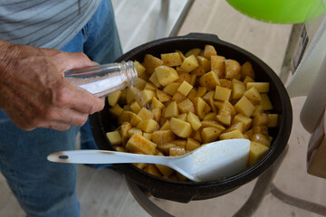 Dutch oven with fried potatoes and a big metal spoon