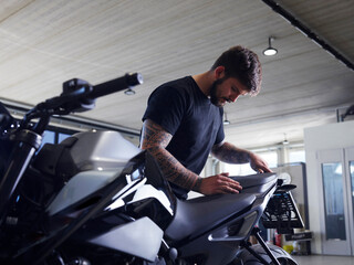 Repairman installing motorcycle seat at workshop