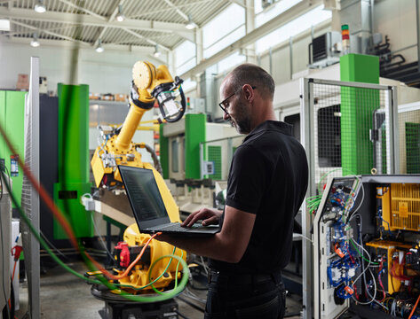 Male Engineer using laptop in industry
