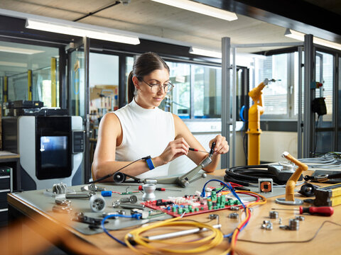 Female engineer working with electrical component in industry