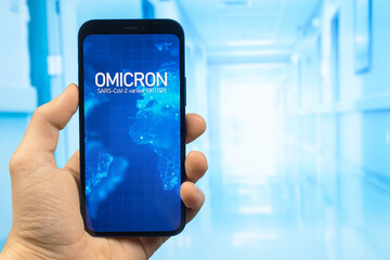 Doctor hand holds mobile phone with text Omicron variant of coronavirus. Hospital background. Design for news web sites. SARS-CoV-2, B.1.1.529. World epidemic concept photo