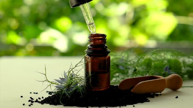 Black cumin oil in a bottle. Selective focus.