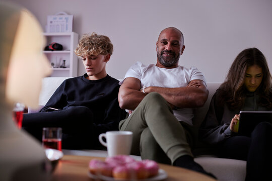 Father with children sitting on sofa