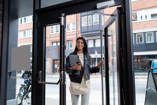 Smiling woman entering office