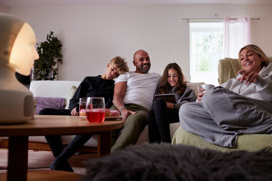 Smiling family relaxing on sofa - Powered by Adobe